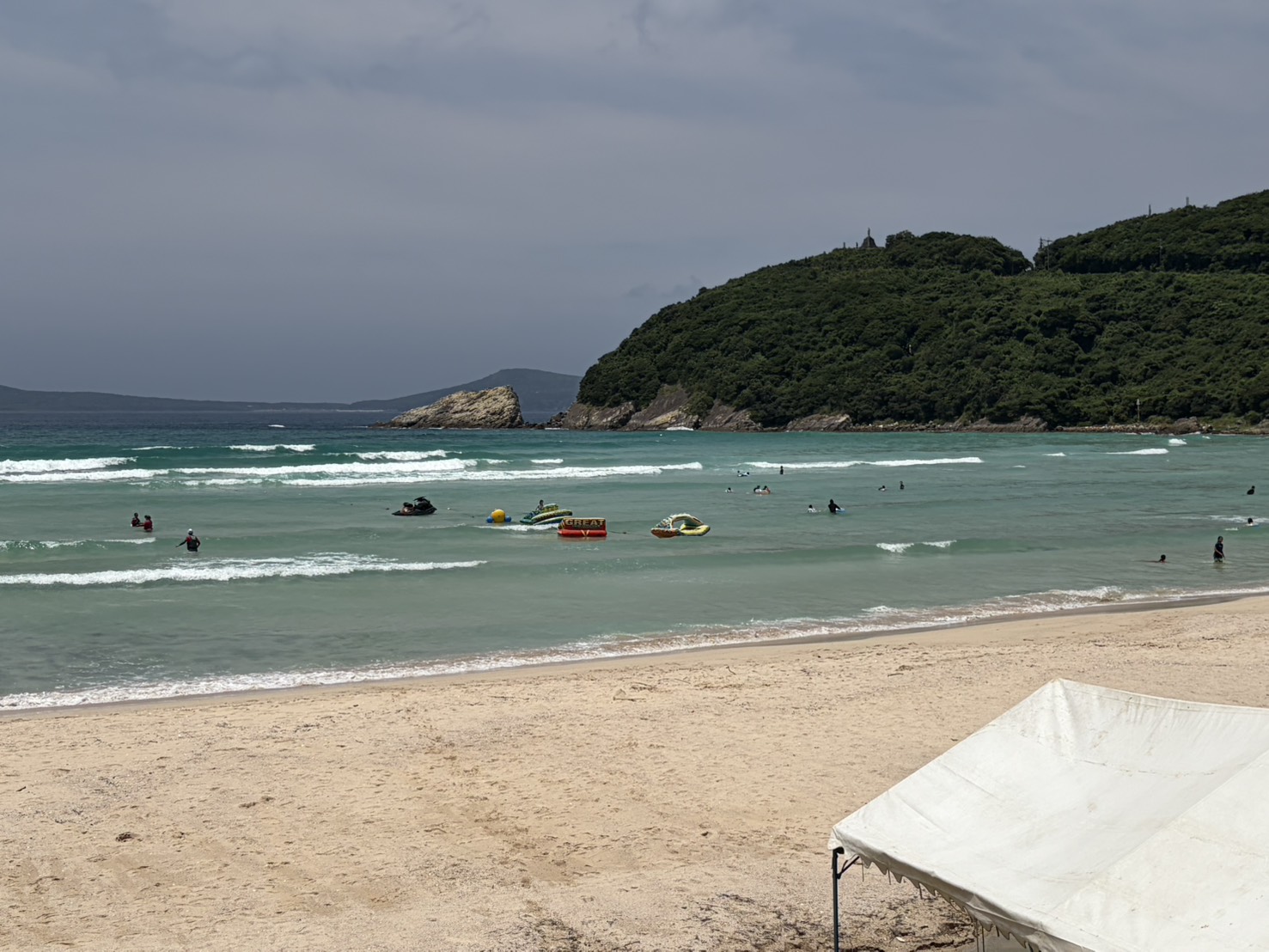 白い砂浜と波打ち際で遊ぶ人々
