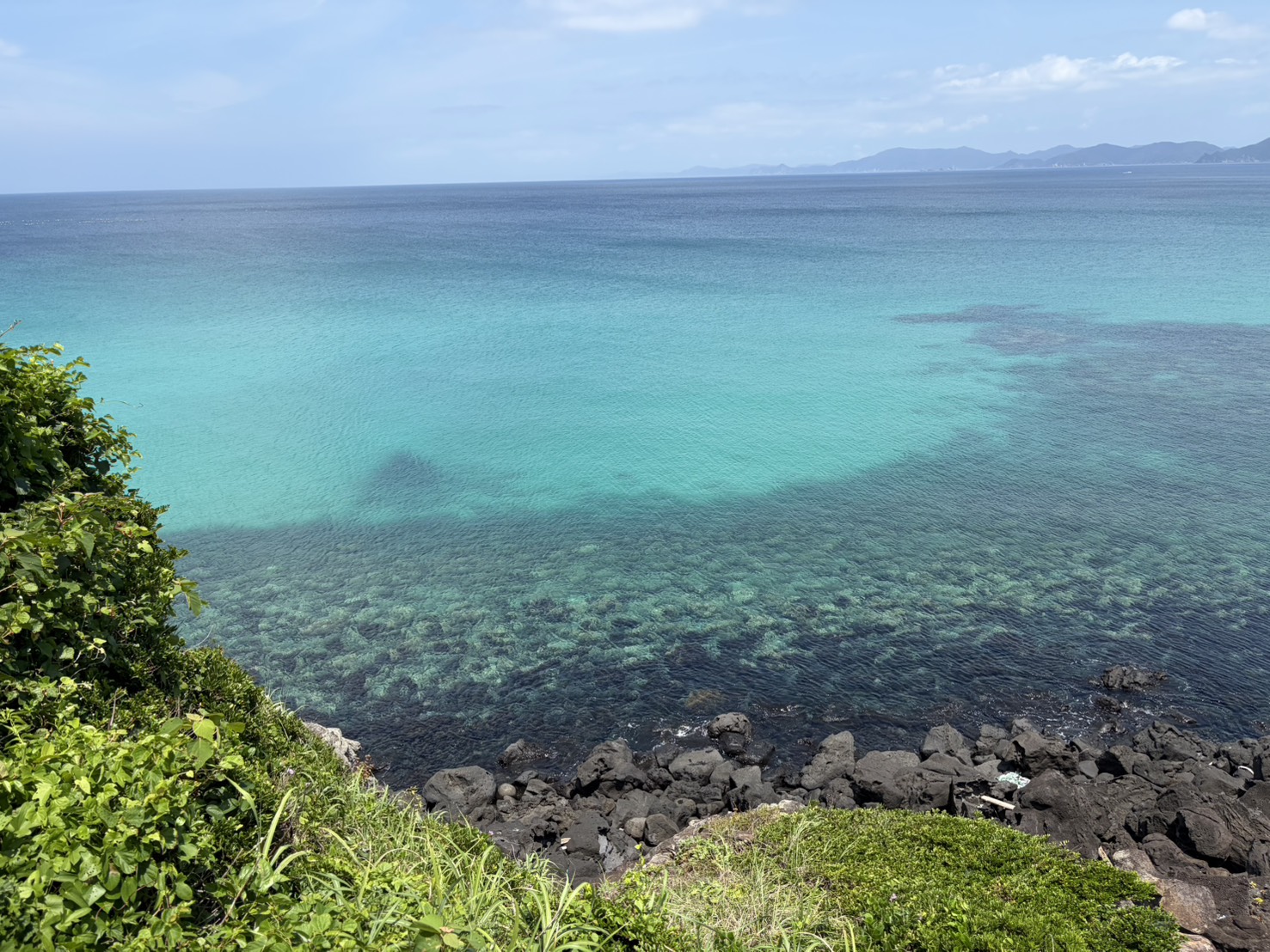 岩場から見下ろす透明度抜群の青い海