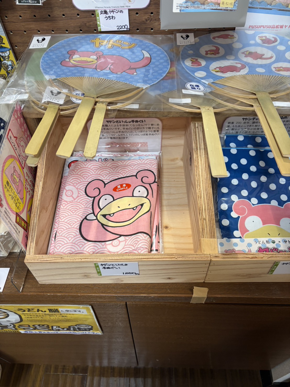 ヤドンが描かれたうちわやタオルのグッズ