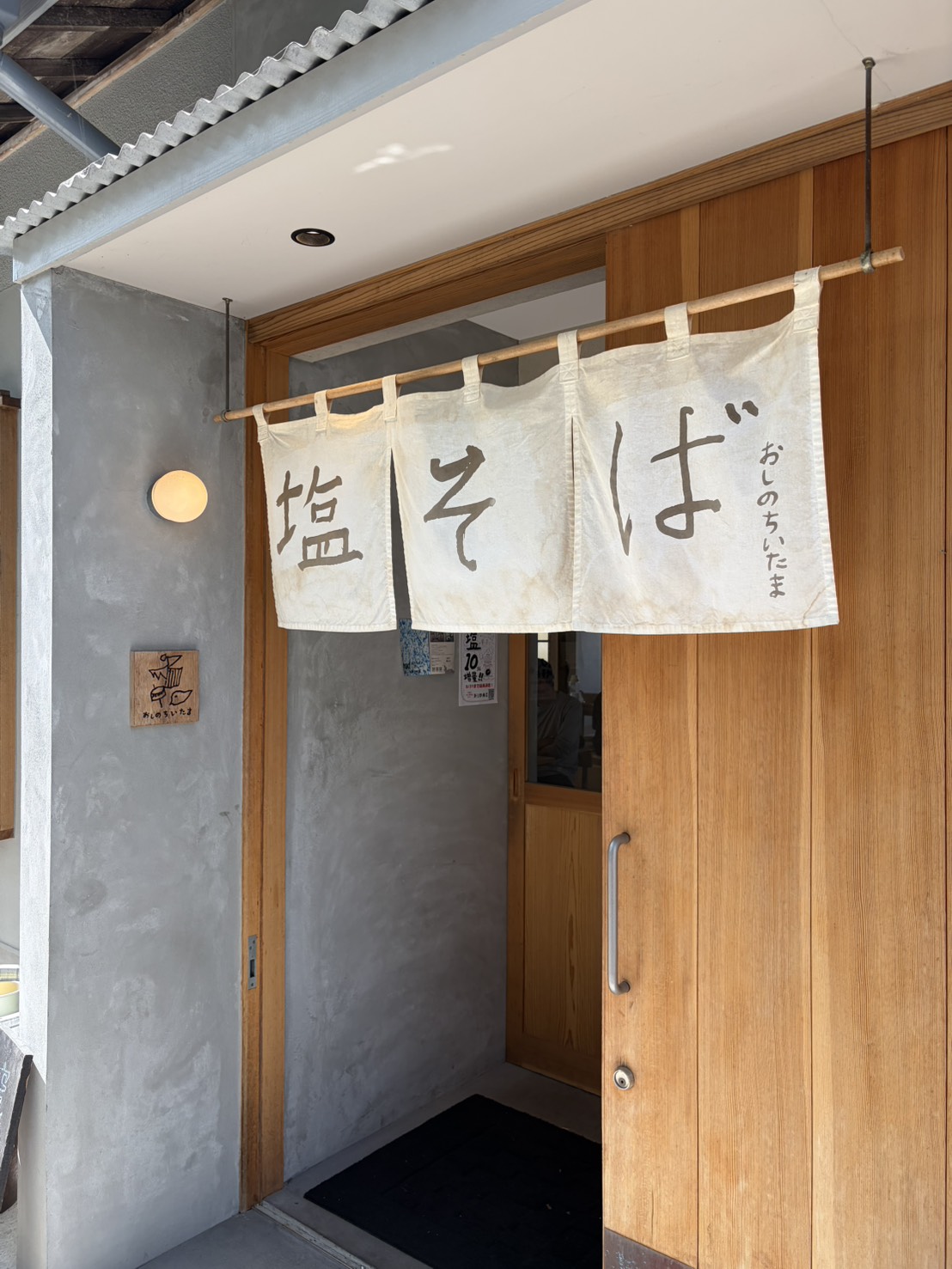 「塩そば」と書かれた白い暖簾がかかる店舗入口