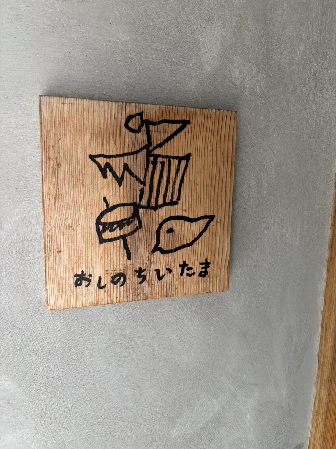 「おしのちいたま」と描かれた温かみのある木製看板