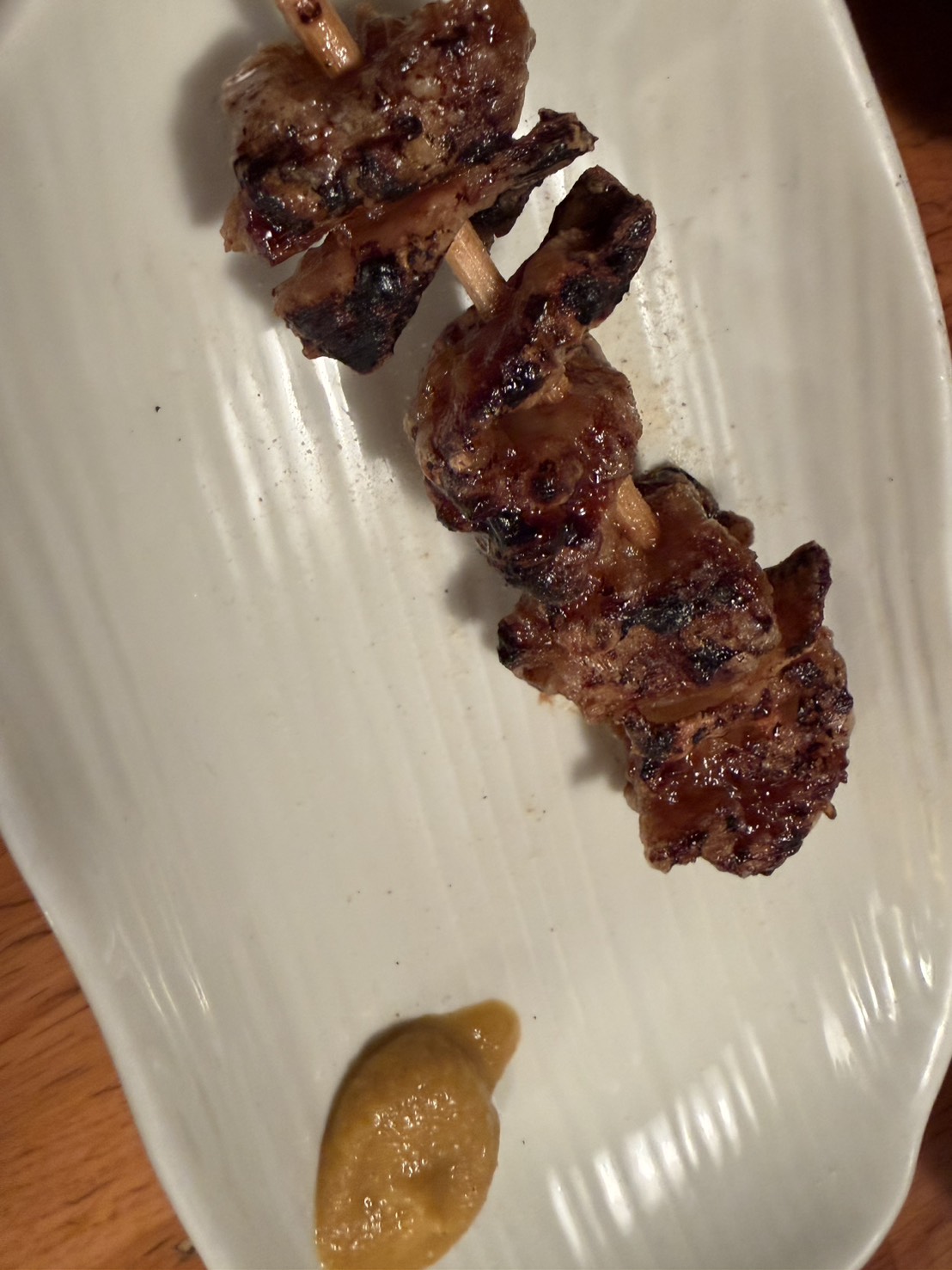 辛子が添えられた香ばしいタレの焼き鳥串