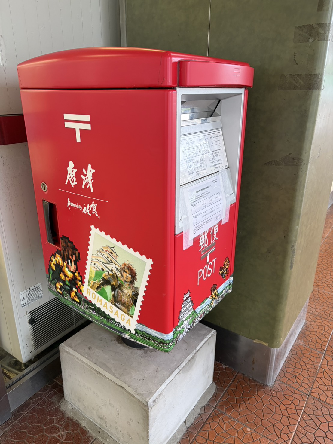 唐津の文字とステッカーで装飾された赤い郵便ポスト