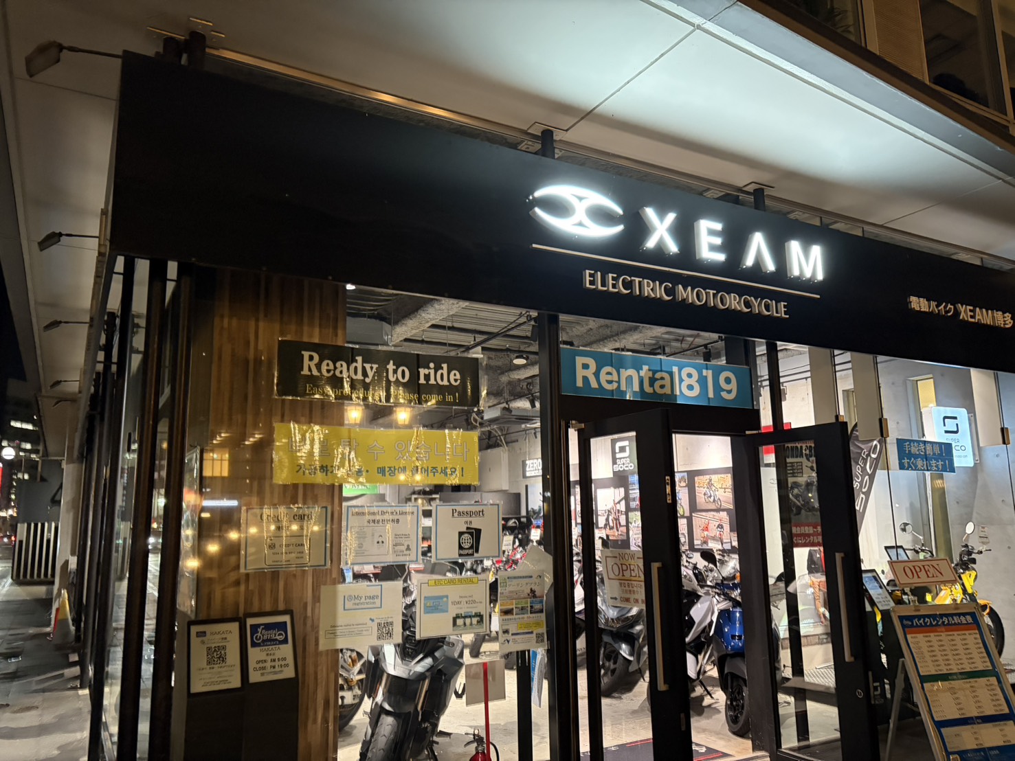 夜の街に光るXEAM博多の店舗外観